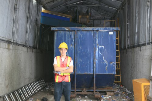 Operative performing a site risk check near a skip